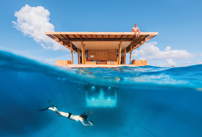 Enlargeable image of a hotel room half underwater and someone diving