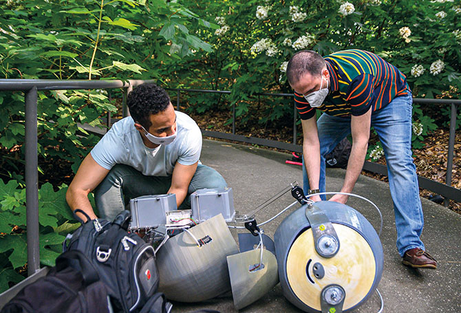 Two people working on a the robot sloth